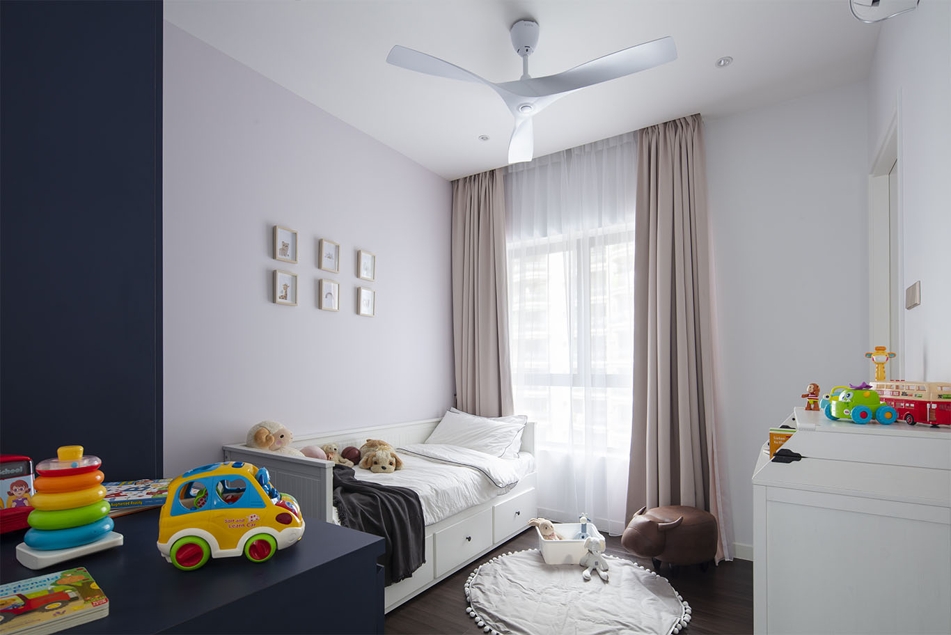 Kids bedroom with white and blue theme, single bed with built in drawer, wooden floor and cute white round carpet