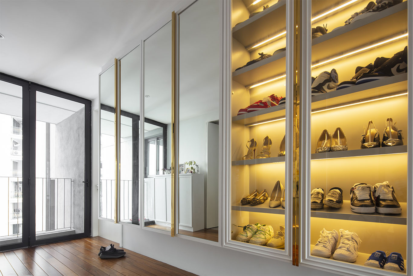 Modern hallway with glass shoe rack with hidden gold light